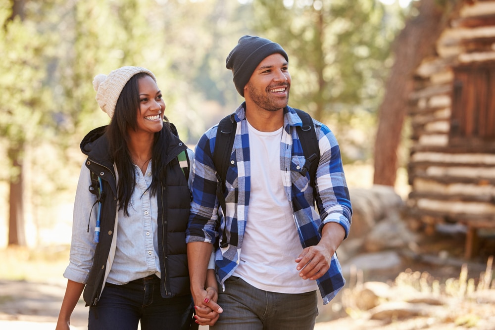 A young black couple enjoying romantic cabin getaways in the fall