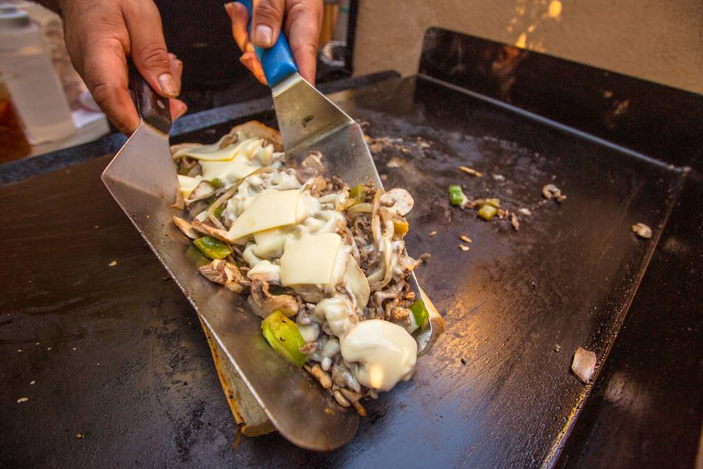 A cook making the best philly cheesesteak in Philadelphia